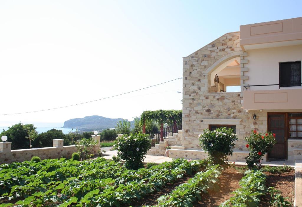 a villa with a garden in front of a building at Romantica Apartments in Falasarna