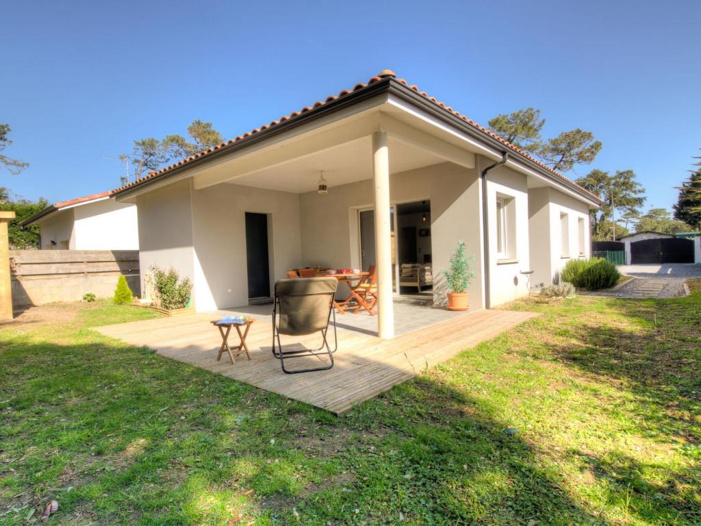 a house with a deck and a chair in the yard at Holiday Home La Plage by Interhome in Labenne