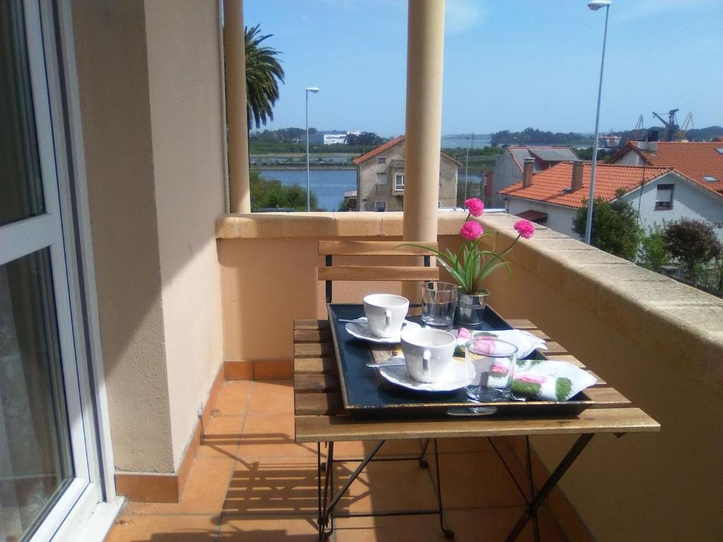 einen Tisch auf einem Balkon mit einem Tablett mit Speisen in der Unterkunft Residencial "La Ventilla" in Guarnizo