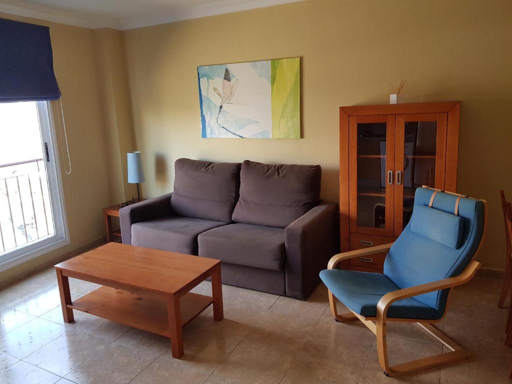 サンタクルス・デ・テネリフェにあるApartamento en Santa Cruzのリビングルーム(ソファ、椅子、テーブル付)