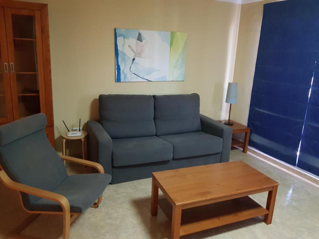 サンタクルス・デ・テネリフェにあるApartamento Santa Cruz de Tenerifeのリビングルーム(青いソファ、テーブル付)