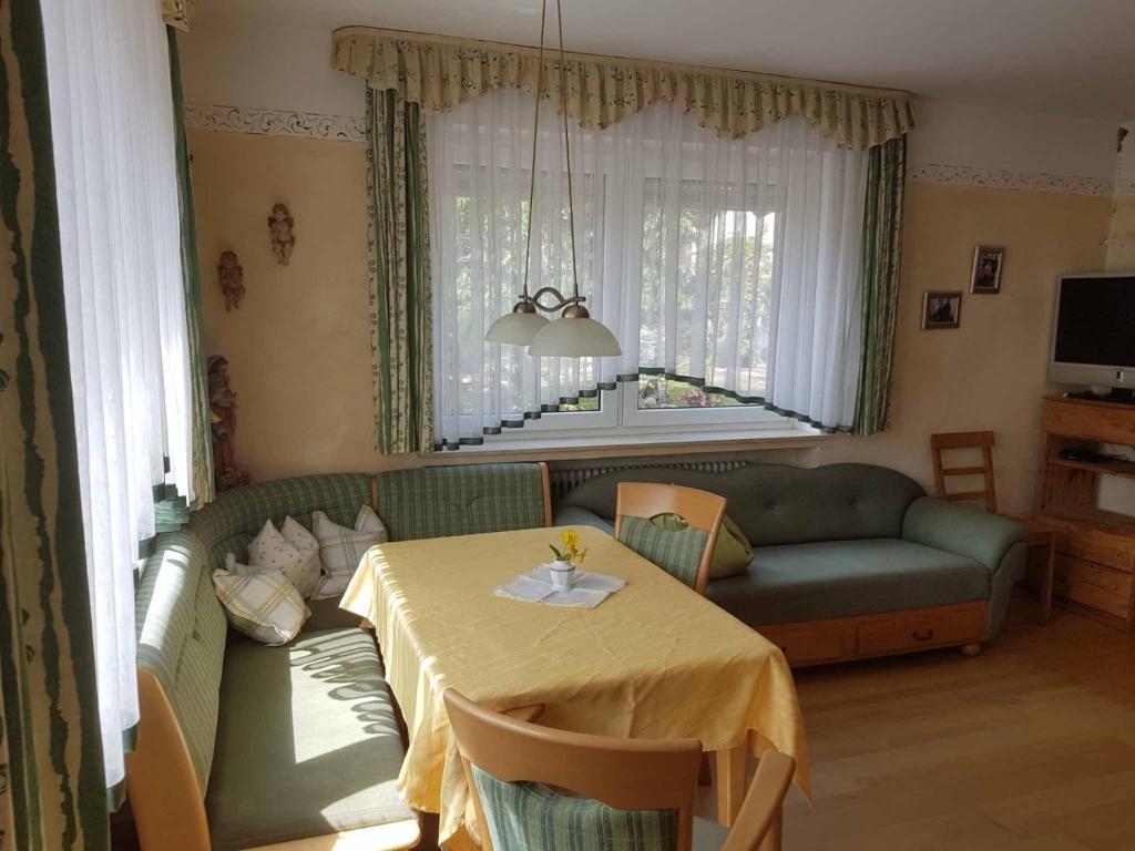ein Wohnzimmer mit einem Tisch und einem Sofa in der Unterkunft Beim Dobis in Lutzingen