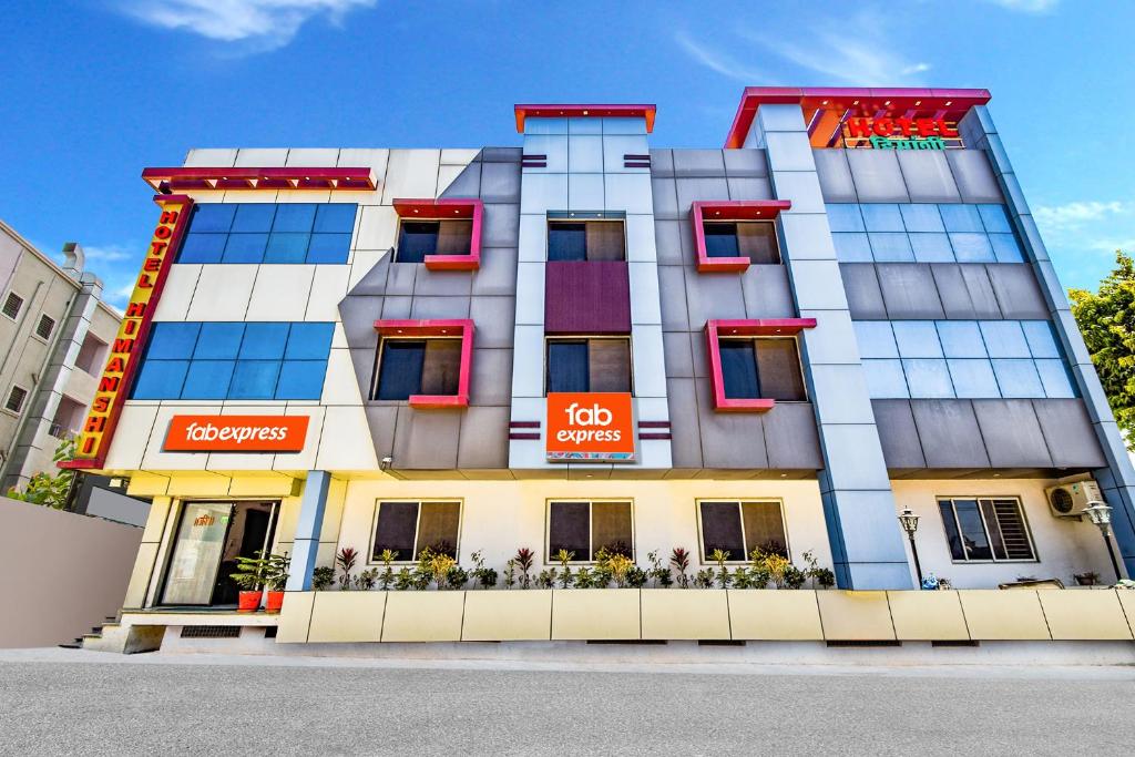 a large building with red windows on a street at FabHotel Himanshi in Udaipur