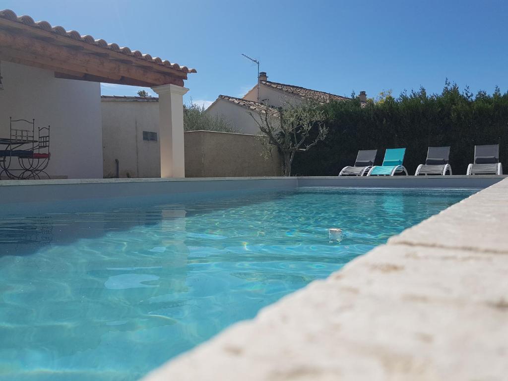 una piscina con sedie in un cortile di la maison de celine a Beaumes-de-Venise