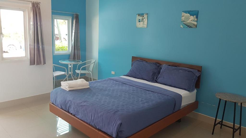 1 dormitorio con cama y pared azul en The Moonlight Resort en Ban Chang