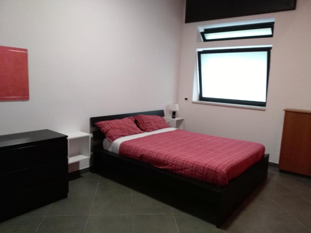 una camera con letto rosso e finestra di Caterinette a Bisceglie