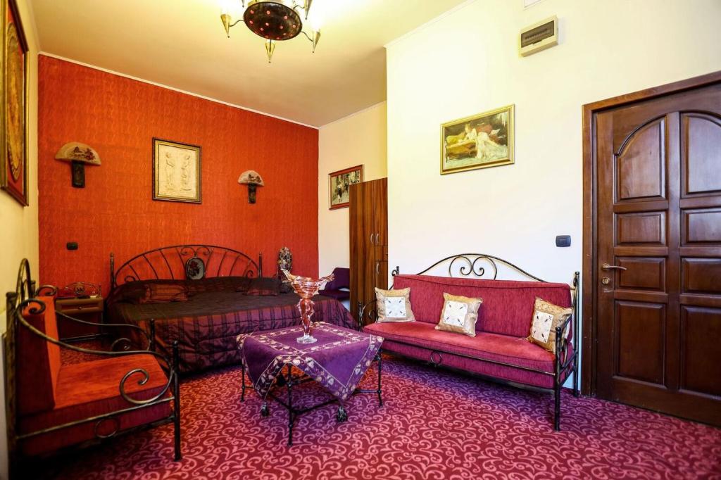 sala de estar con muebles de color rojo y puerta en Voila Inn, en Constanţa
