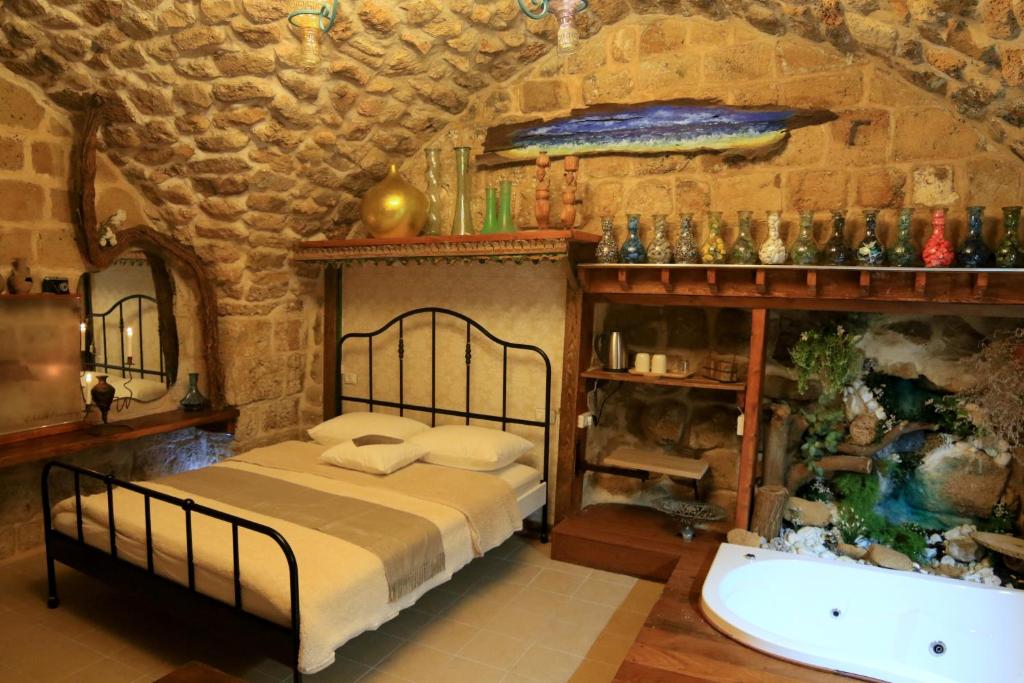 una camera con letto e vasca da bagno di Ashash House a ‘Akko