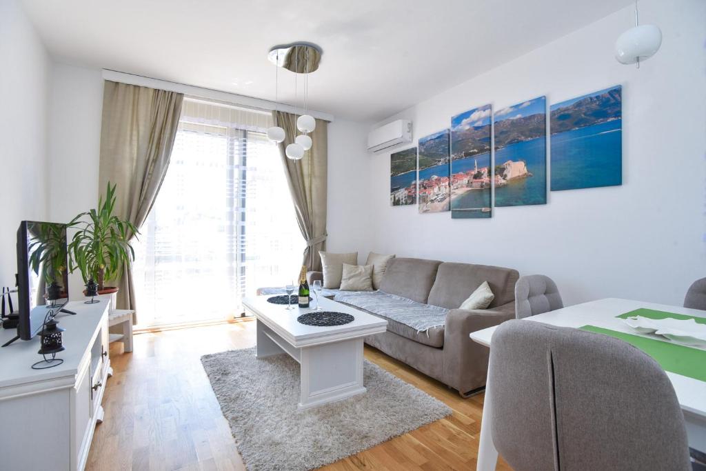 ein Wohnzimmer mit einem Sofa und einem Tisch in der Unterkunft Apartment Bojana in Budva