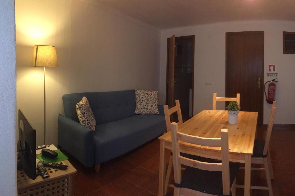 salon z niebieską kanapą i drewnianym stołem w obiekcie Casa da Avó Tina - Apartamento w mieście Castelo de Vide