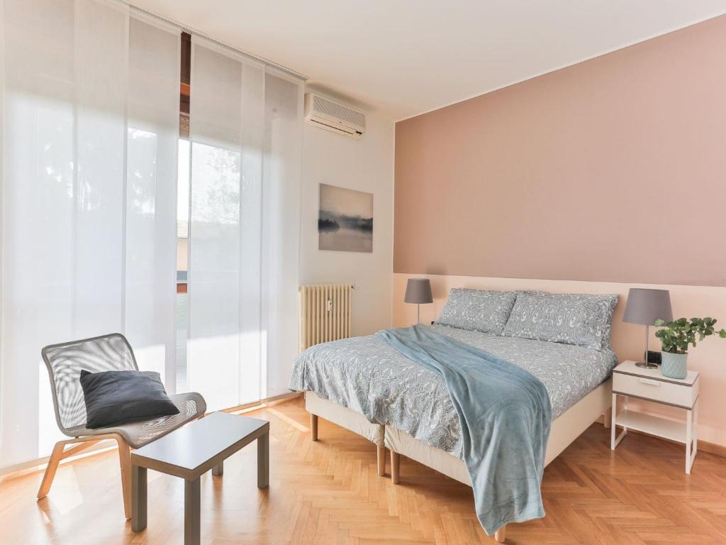 1 dormitorio con 1 cama y 1 silla en The Best Rent - Big apartment near San Siro stadio en Milán
