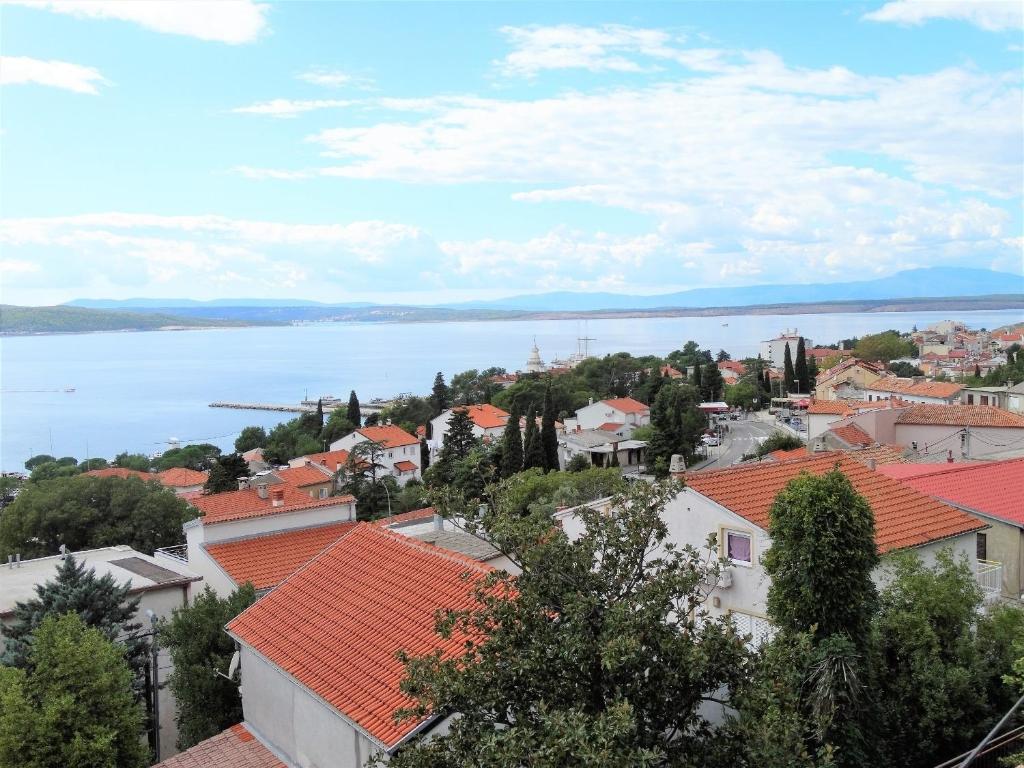 uma vista para uma cidade com telhados de laranja e um corpo de água em Apartments Iva em Crikvenica