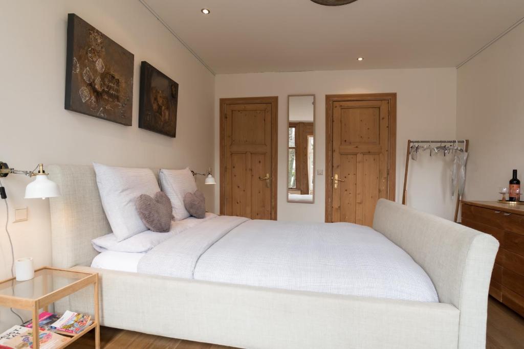 ein weißes Schlafzimmer mit einem weißen Bett und einem Tisch in der Unterkunft A B&B Amsterdam in Amsterdam