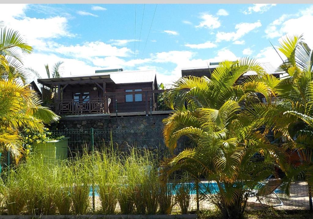 a house with a deck on top of a building at Les Vanilliers Location BUNGALOWS in Saint-Joseph