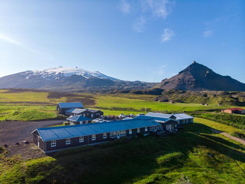 uma vista aérea de um edifício com uma montanha ao fundo em Fosshotel Hellnar em Hellnar