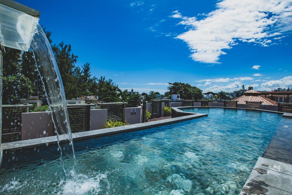 a swimming pool with a fountain on top of a building at Aanari Hotel & Spa in Flic-en-Flac