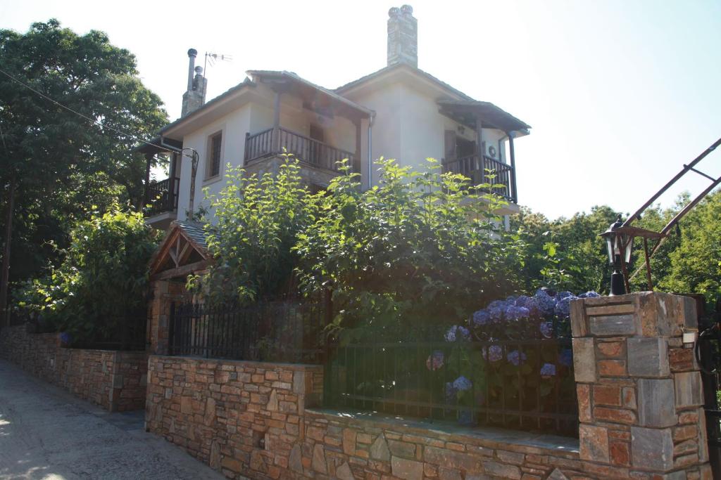 une clôture en briques devant une maison dans l'établissement Guesthouse Xenioti, à Tsagkarada