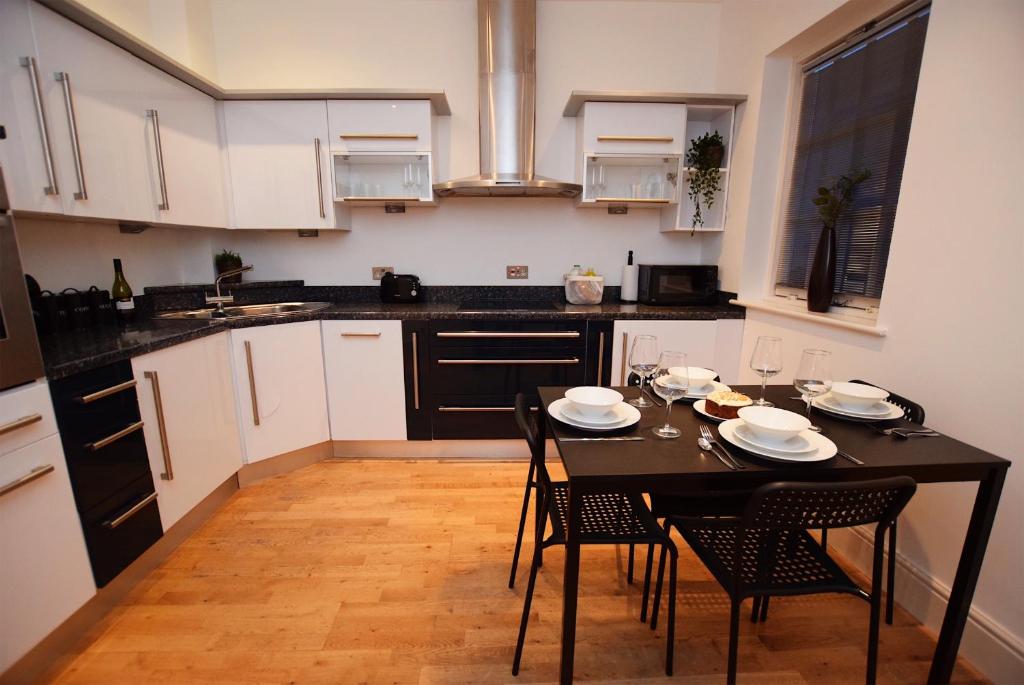 a kitchen with a black table and chairs in it at Derby Town House 1 min to town in Derby