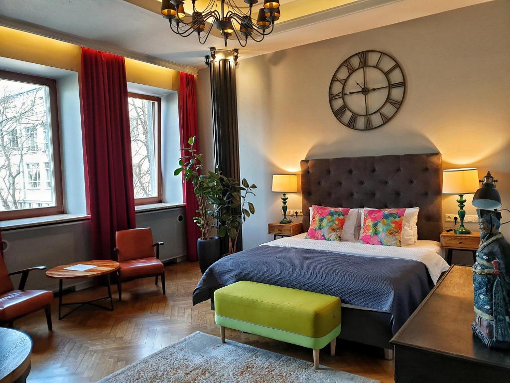 1 dormitorio con 1 cama y reloj en la pared en SleepWell Apartments Ordynacka, en Varsovia