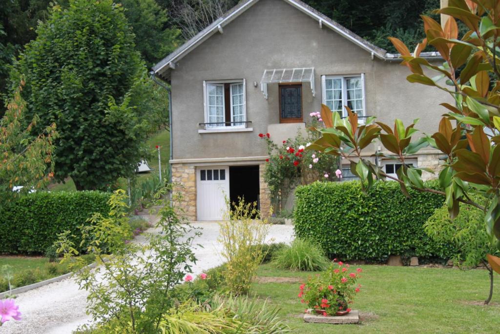 une maison avec une porte blanche et quelques fleurs dans l'établissement Maison de Gaby 2 étoiles tourisme 2 ou 4 Personnes, à Vitrac