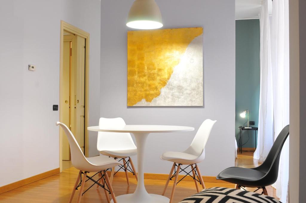 una sala da pranzo con tavolo e sedie bianchi di Residenza Fiori Oscuri a Milano