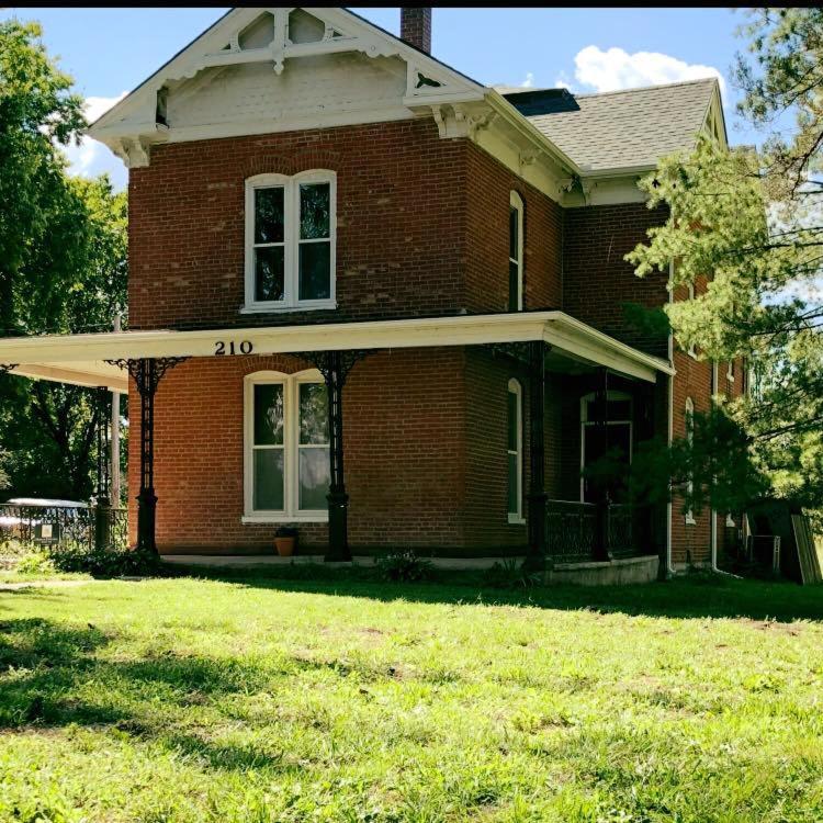 a brick house with a large yard in front of it at Smithville Historical Museum and Inn in Smithville