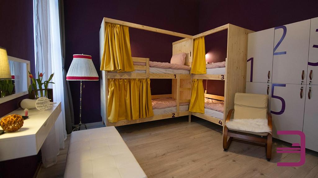 a bedroom with two bunk beds with yellow curtains at InVerve Hostel in Timişoara
