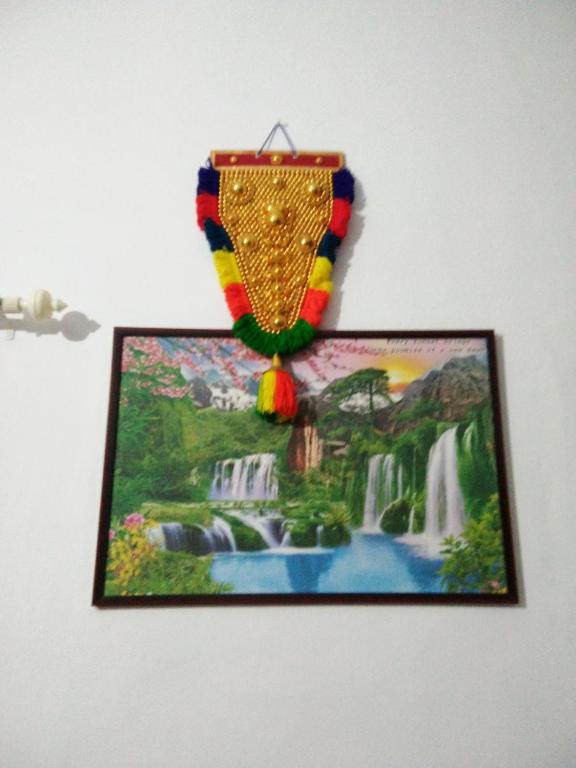 a picture hanging on a wall with a painting at Nunu Homestay Guruvayoor in Guruvāyūr