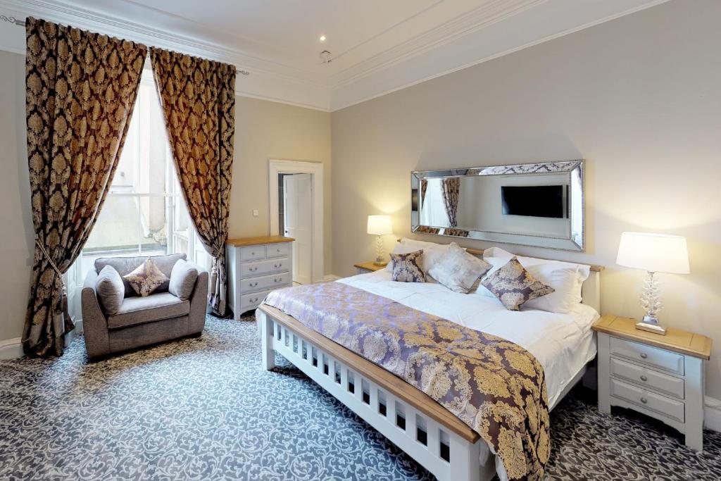 a bedroom with a large bed and a chair at The Townhouse in Cork