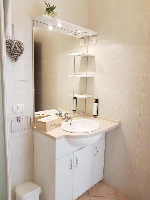 łazienka z umywalką i lustrem w obiekcie Home Suite Home w mieście Cavaion Veronese