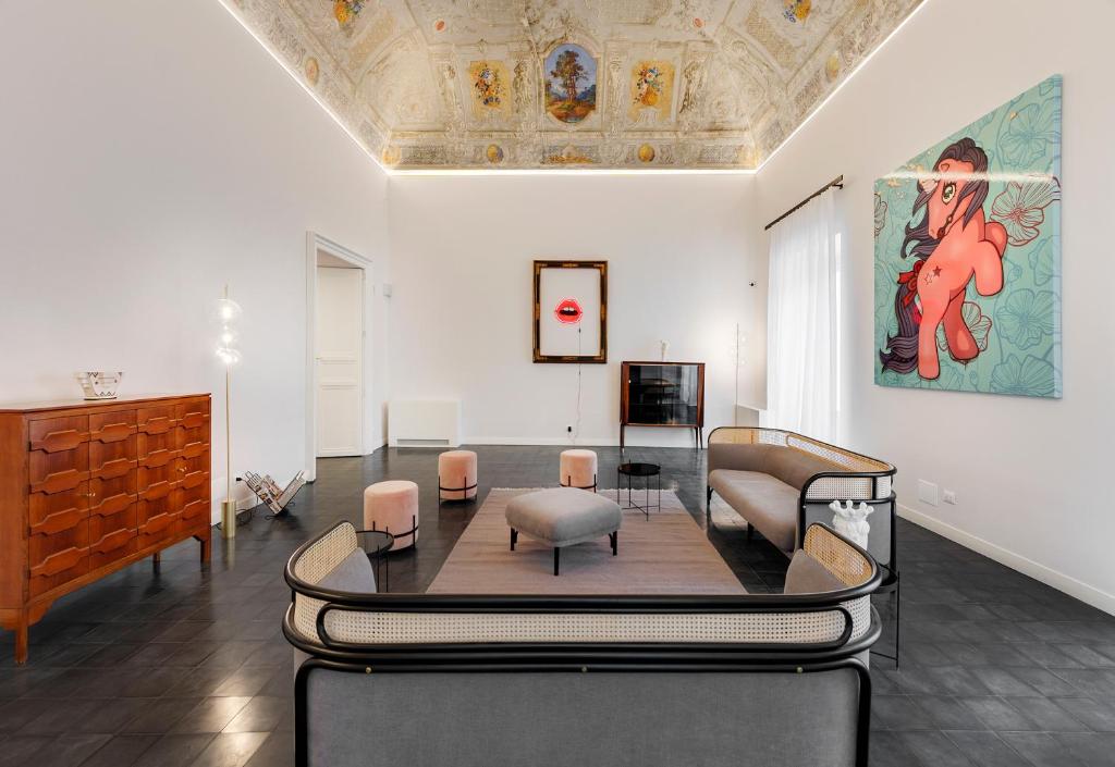 a room with chairs and a table and a painting at A.D. 1768 Boutique Hotel in Ragusa