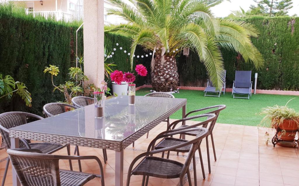 una mesa y sillas en un patio con una palmera en Rey Don Jaime en Benidorm