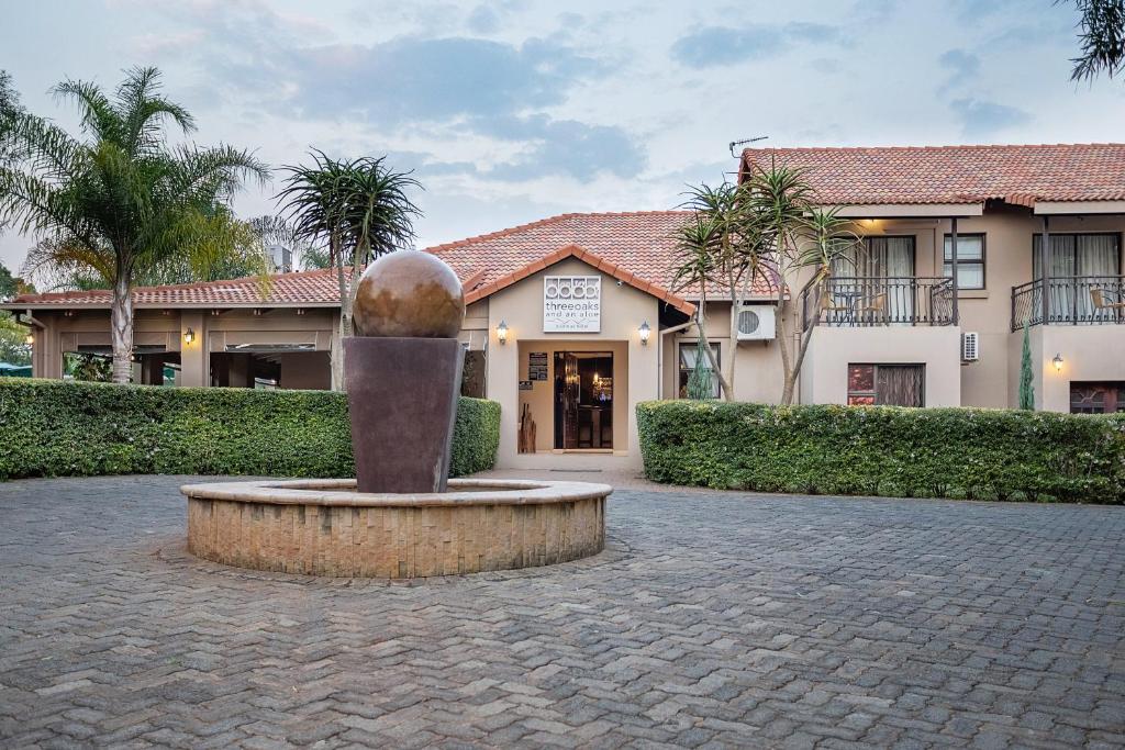 a building with a statue in front of a building at Three Oaks and an Aloe Boutique Hotel in Hartbeespoort