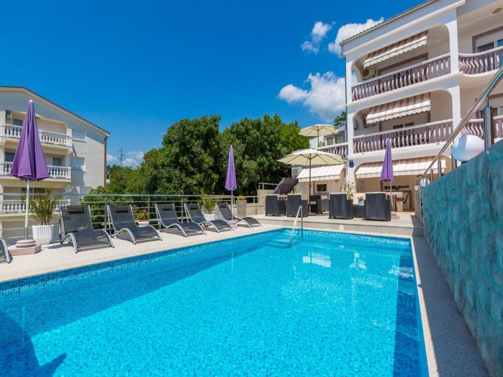 una piscina con sedie e un edificio di Apartments Jordanka a Crikvenica
