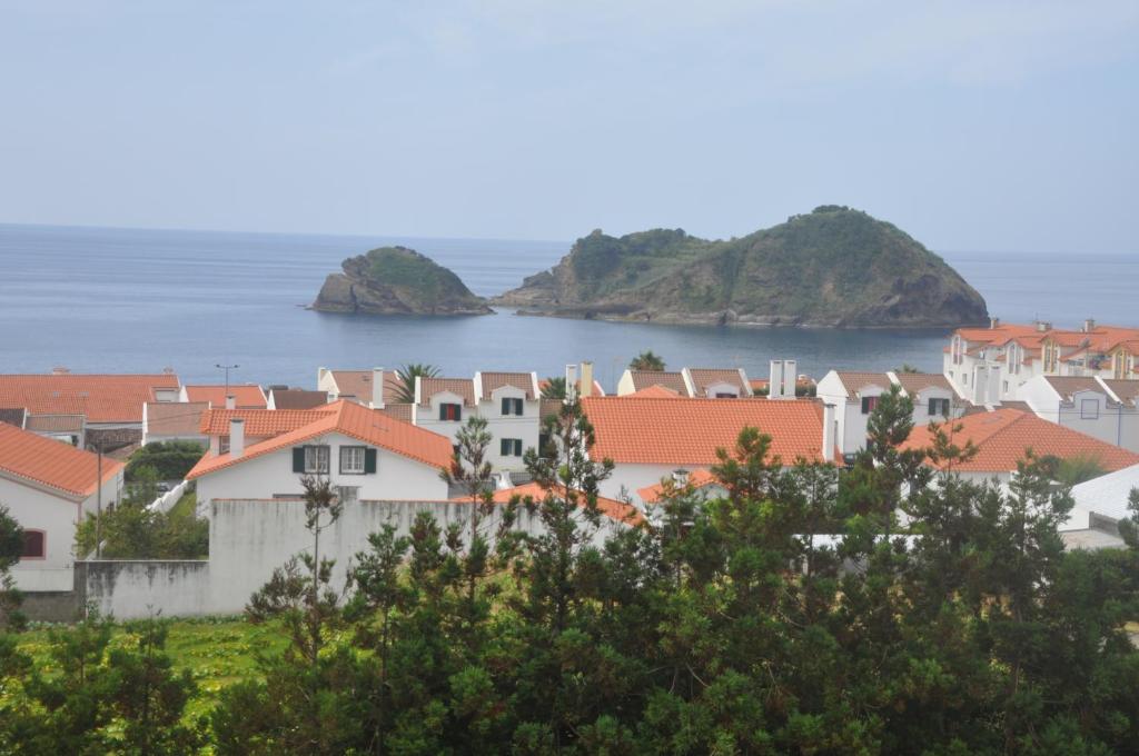 a city with houses and the ocean in the background at Convento de São Francisco in Vila Franca do Campo