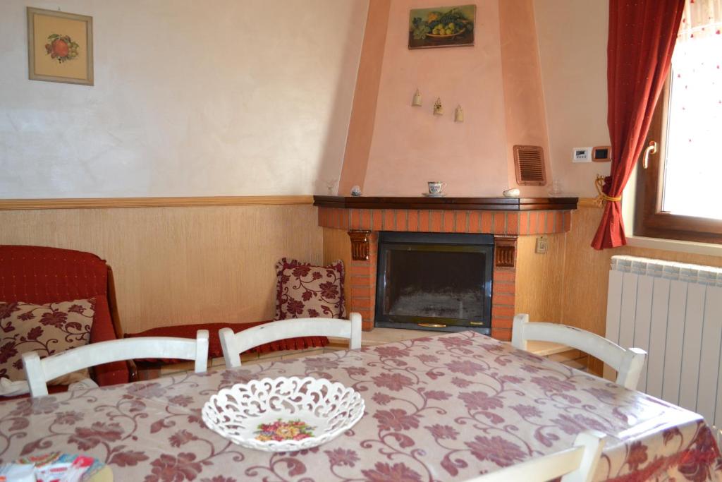 jadalnia ze stołem, krzesłami i kominkiem w obiekcie Appartamento Isola D'oro w mieście Piazza Armerina