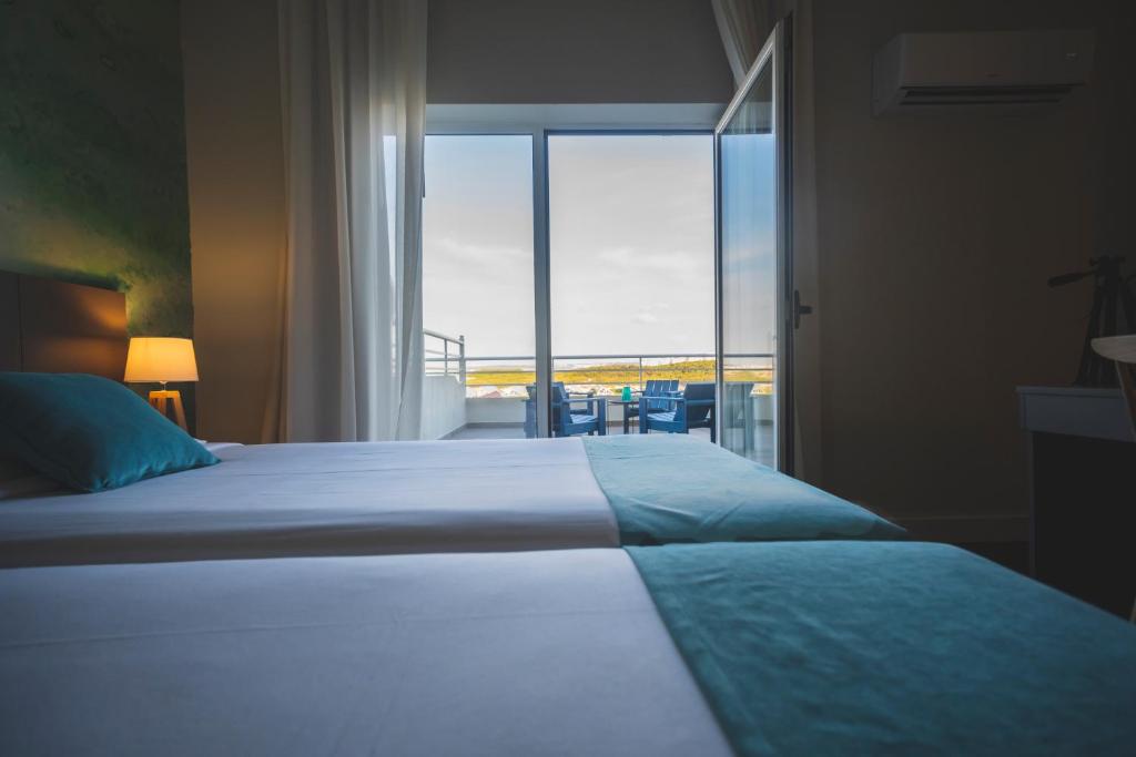 a bedroom with a bed and a large window at Star inn Peniche in Peniche