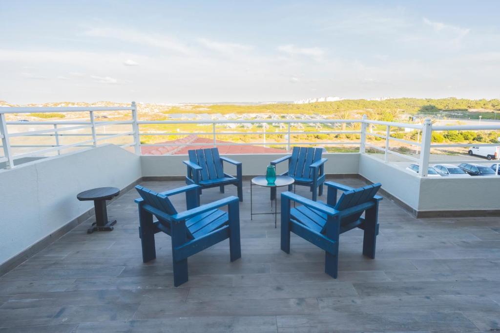 a balcony with four blue chairs and a table at Star inn Peniche in Peniche
