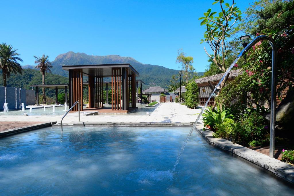 a pool with a water fall in front of a building at Yang Ming Shan Tien Lai Resort &amp; Spa in Jinshan