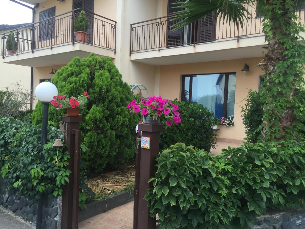 un edificio con due pali con sopra dei fiori di Villa Muse Holiday Locazione Turistica sul mare Capo Mulini, Acireale - Sicilia, Italy ad Acireale
