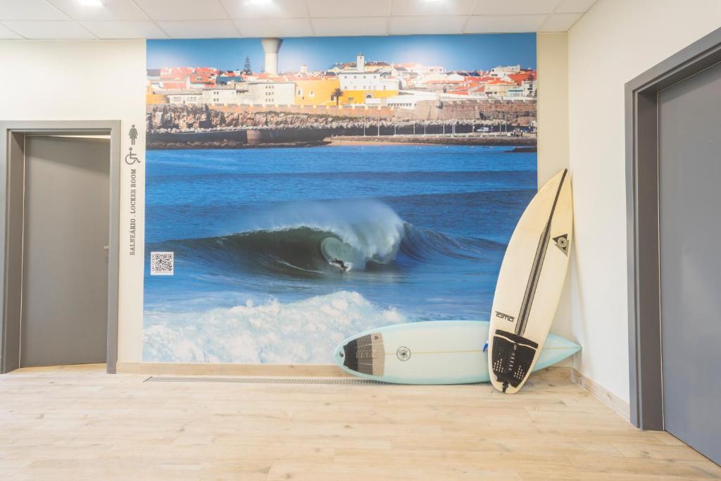 a wall with a painting of a surfer in the ocean at Star inn Peniche in Peniche