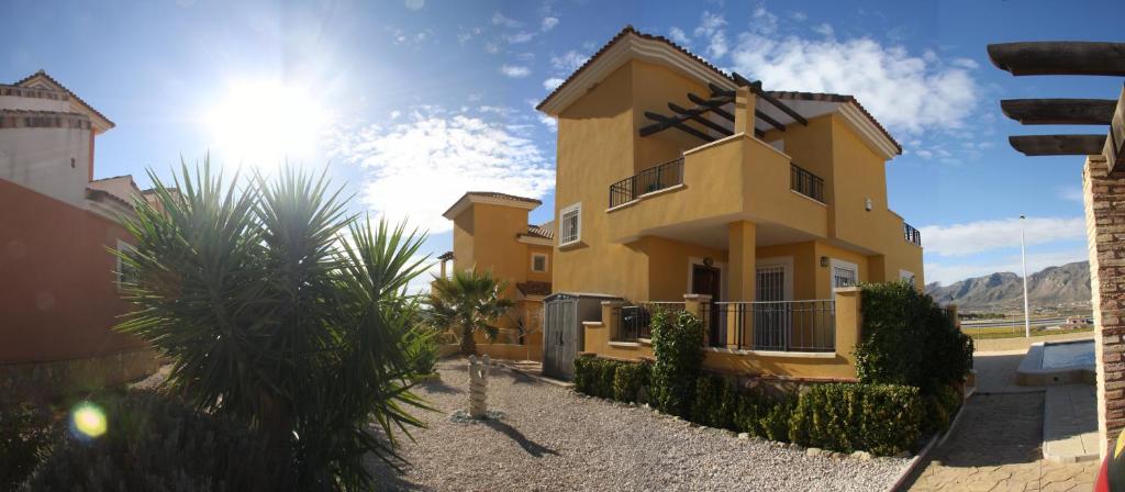 una casa amarilla con el sol en el cielo en Hondon-Villa, en Hondón de las Nieves