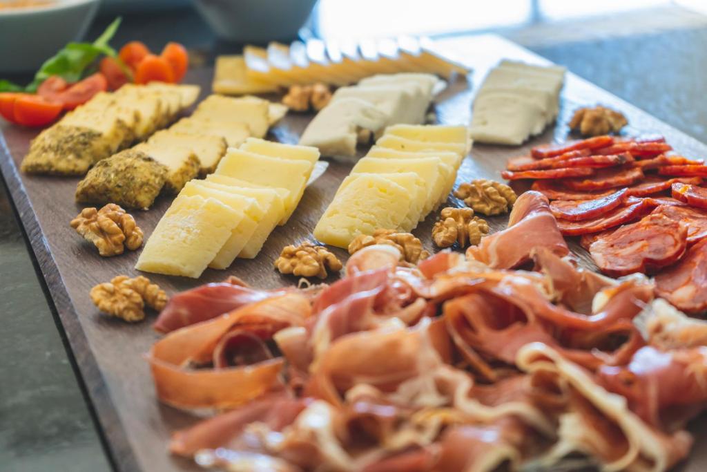 a tray with cheese and other foods on a table at Star inn Peniche in Peniche