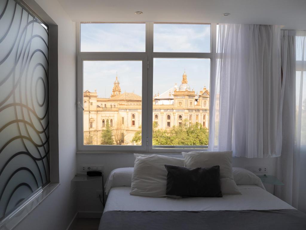 1 dormitorio con ventana y vistas a un edificio en Pasarela, en Sevilla