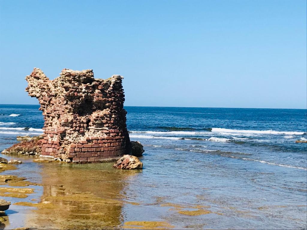 a rock formation in the water on the beach at Casa da Bea in Gonnesa