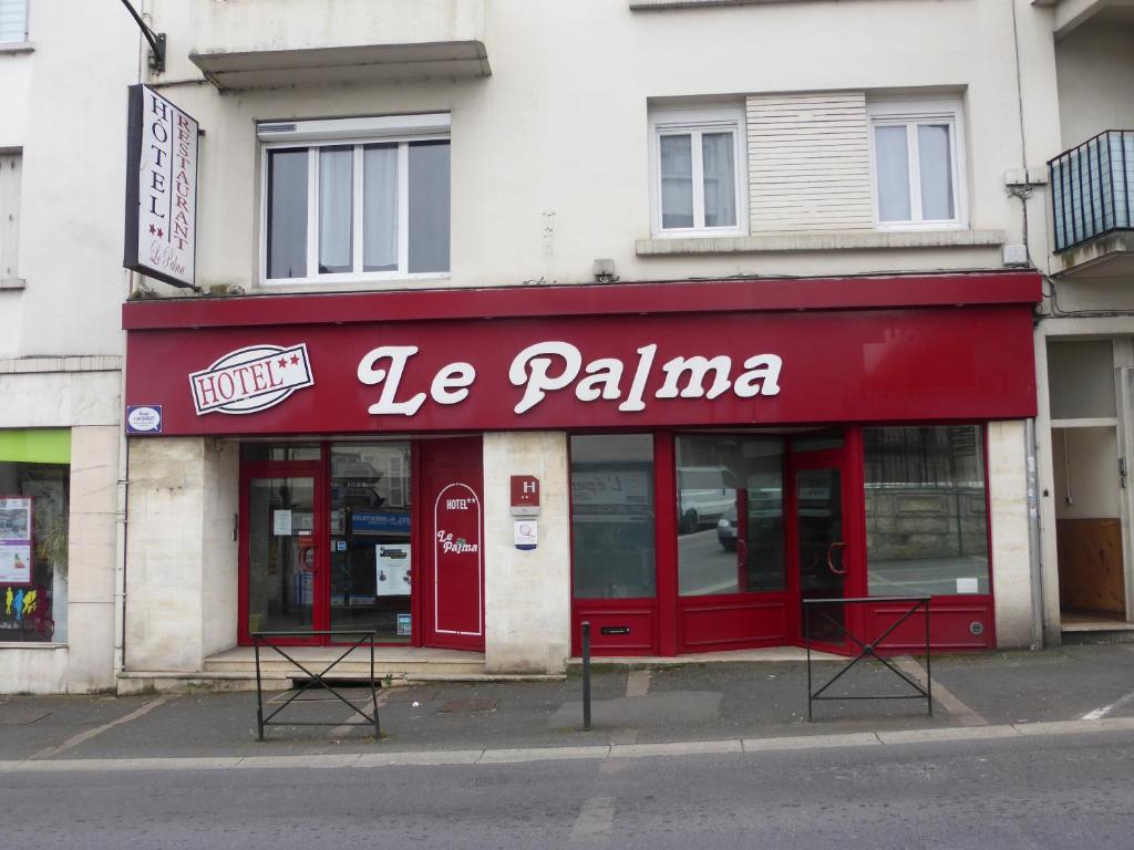 a store with a red sign on the side of a street at Hôtel Le Palma in Angoulême