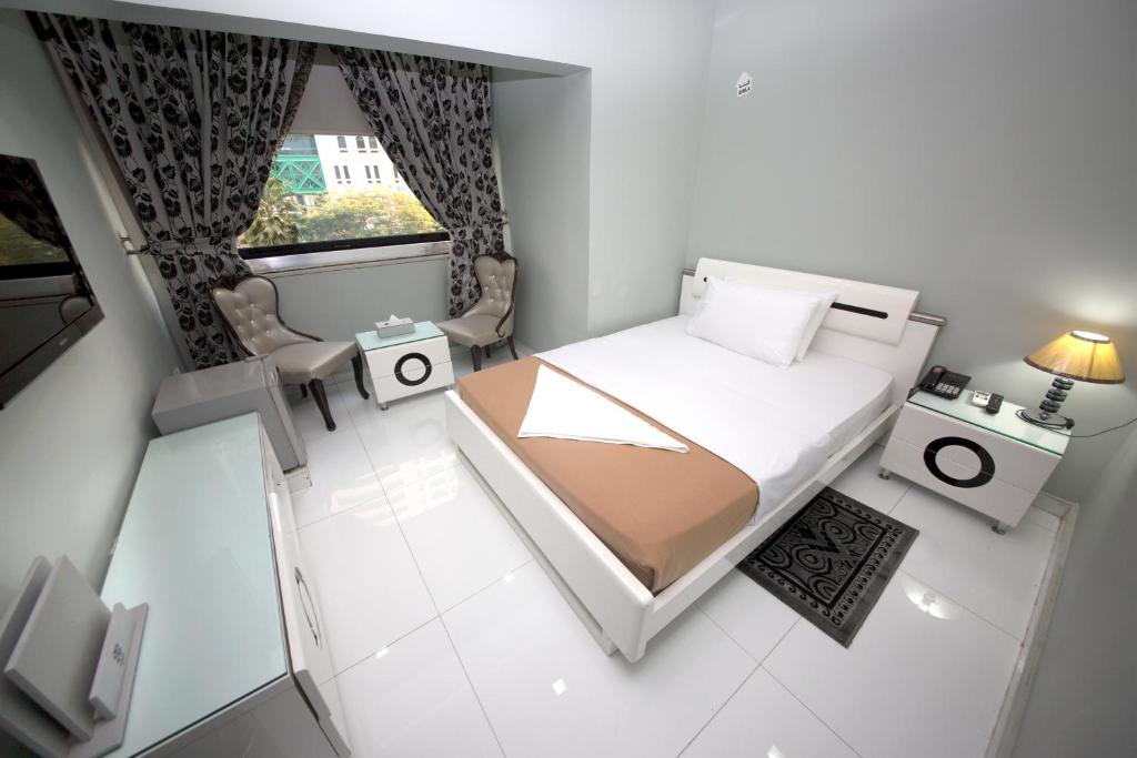 a small room with a bed and a window at White Fort Hotel in Dubai