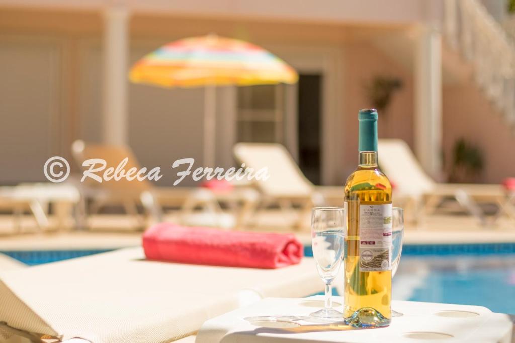 een fles wijn op een tafel naast een glas bij Villa V5 Alvor in Alvor
