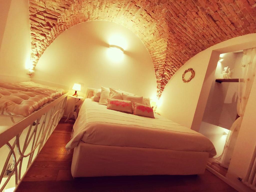 um quarto de hotel com duas camas e uma parede de tijolos em Bologna Boutique Home em Bolonha