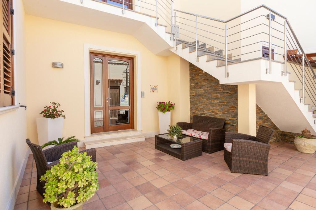 un patio con sillas de mimbre y una escalera en Bed&Breakfast Acasamia, en Castelluzzo